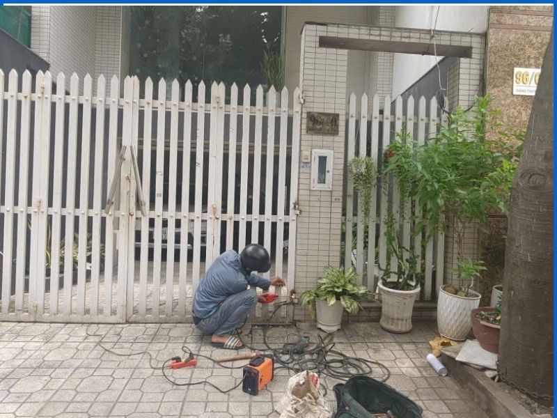 Thợ dùng máy cắt mài xử lý điểm liên kết chân bản lề cửa sắt tại Bình Thạnh